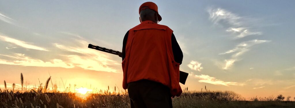 Hunter walking into sunset