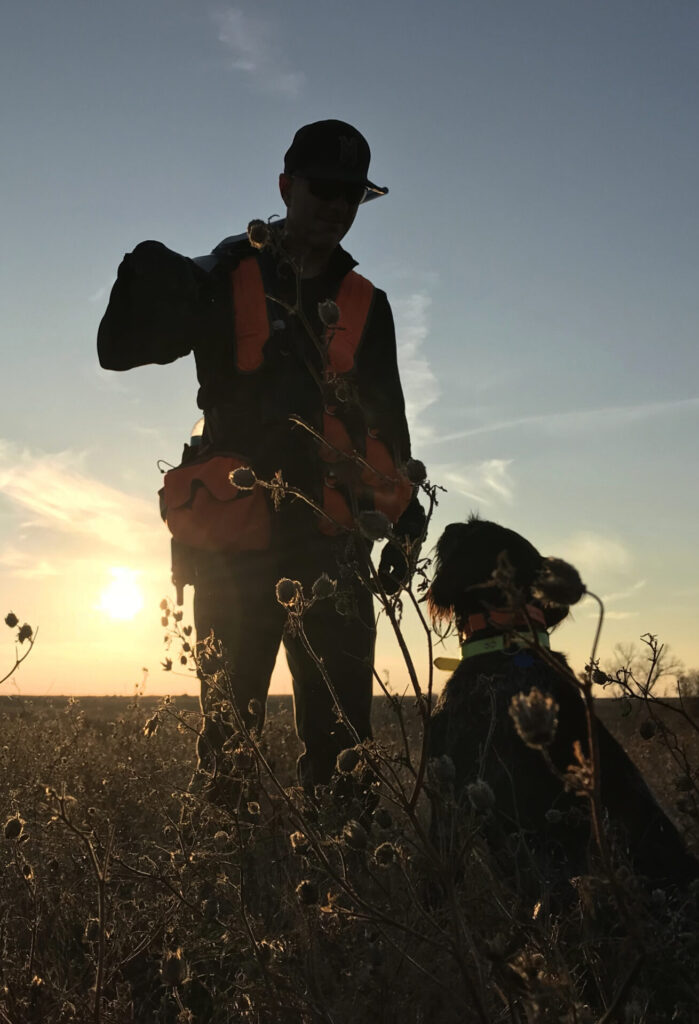 Hunter with dog at sunset
